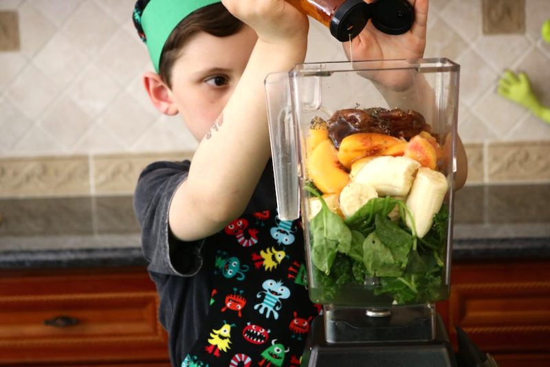 peachy green monster smoothie boy adding agave