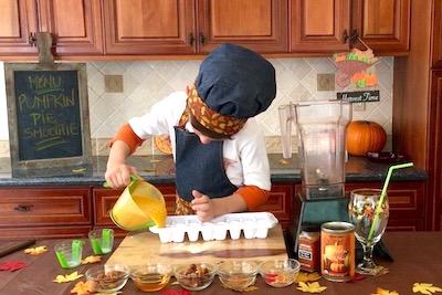 boy pouring pumpkin into ice trays