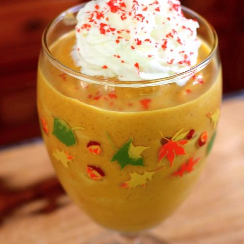 pumpkin pie smoothie with whipped cream and red sprinkles