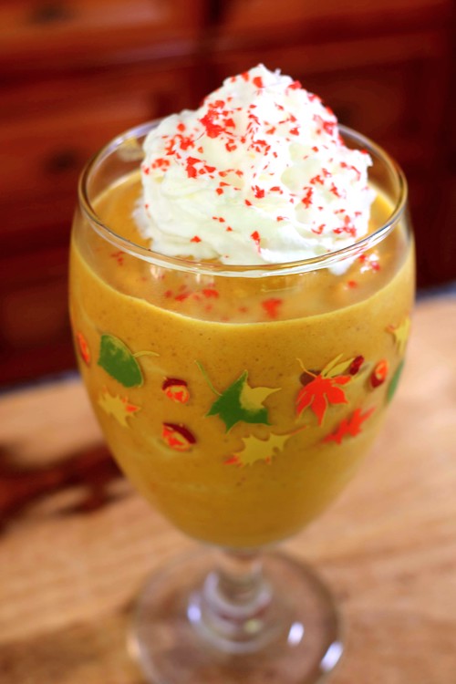 pumpkin pie smoothie with whipped cream and red sprinkles