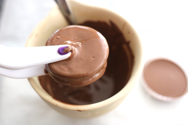 dipping oreo in melted chocolate