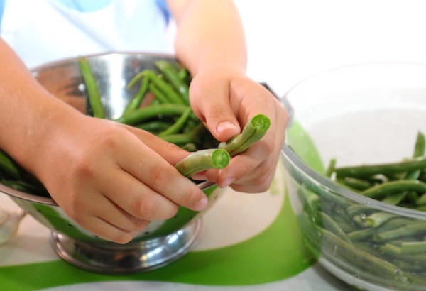 childs hands snapping green bean