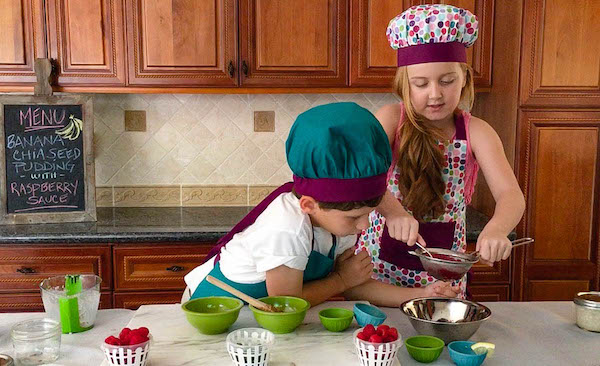 kid making raspberry sauce