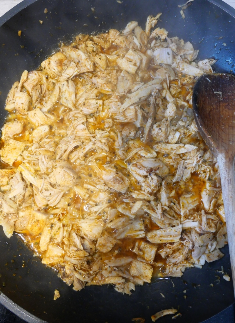close up of leftover chicken taco meat cooking the pan
