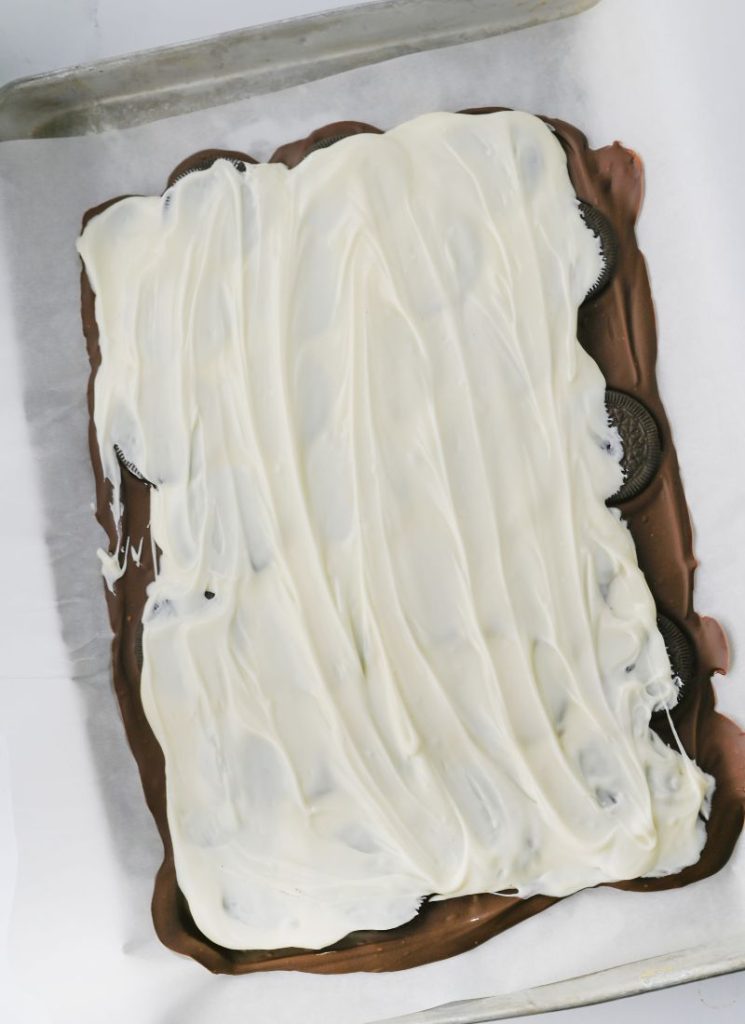 white chocolate poured and spread over the top of the Oreos and milk chocolate