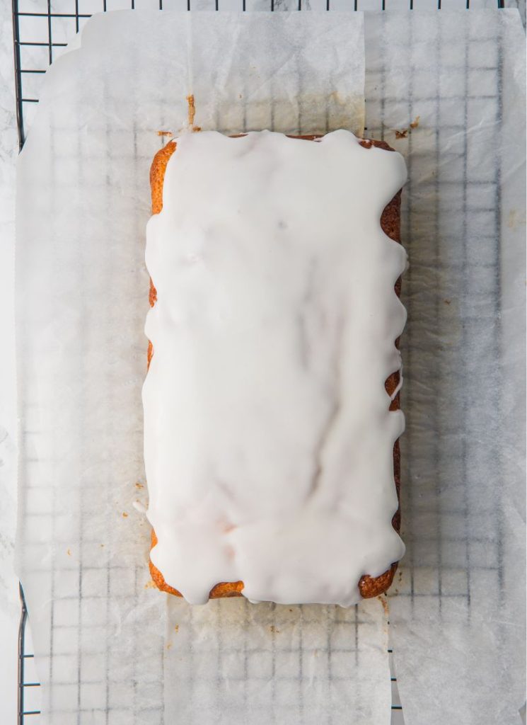 glazed lemon cake sitting on wire rack