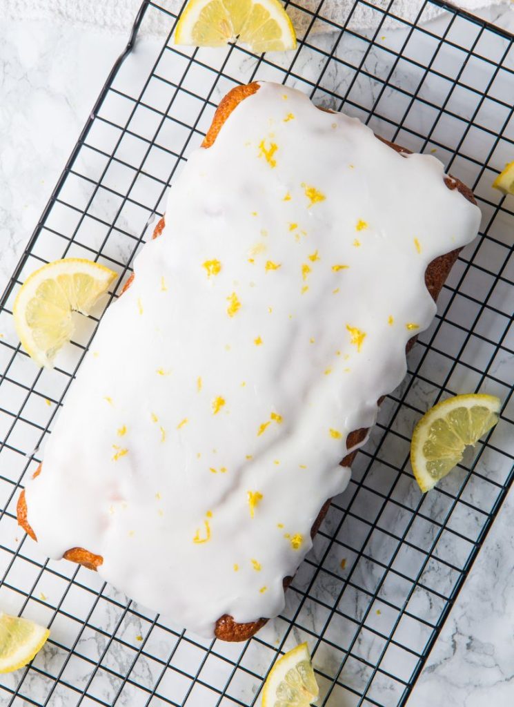 top view of lemon olive oil cake on wire rack with lemon zest garnish